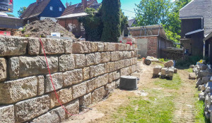 Die Sandsteinmauer während der Bauphase von vorne.